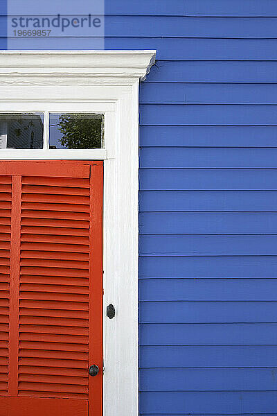 Ein blaues Haus mit leuchtend orangefarbenen Fensterläden in Stonington  CT.