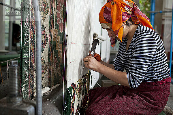 Junge Frauen arbeiten in einer Teppichfabrik außerhalb von Hotan  Xinjiang  China.
