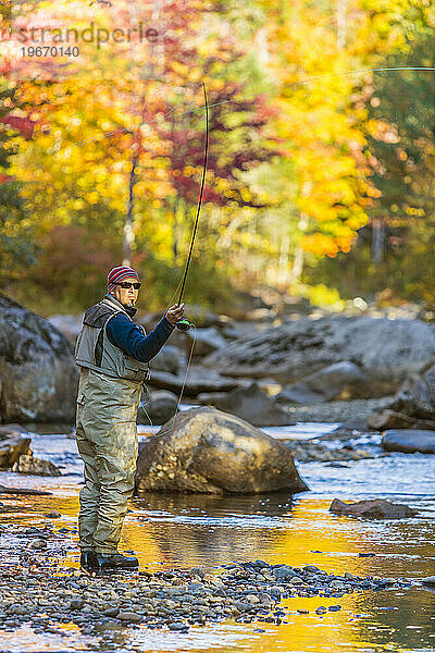 Ein Mann beim Fliegenfischen am Orbeton Stream im Herbst. Gemeinde Madrid  Maine.