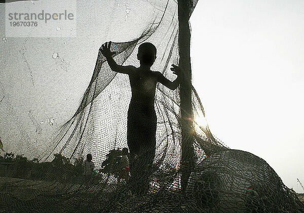 Kinder spielen Fußball in einem armen Fischerdorf in Kuala Terengganu  Malaysia. (Von hinten beleuchtet  Silhouette.)