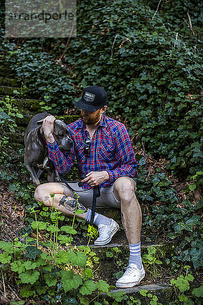 Ein Besitzer sitzt mit seinem Hund in einem Park in Seattle  WA.