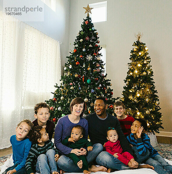Eine multiethnische Familie lacht und lächelt zu Weihnachten gemeinsam