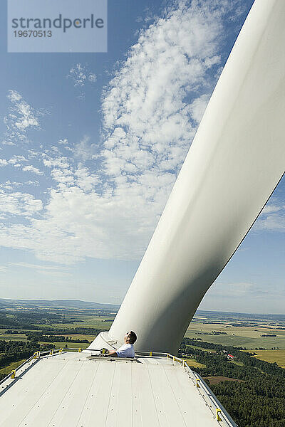 Ein Mann untersucht die Rotorblätter seiner Windkraftanlage in der Nähe von Chodov  Tschechien.