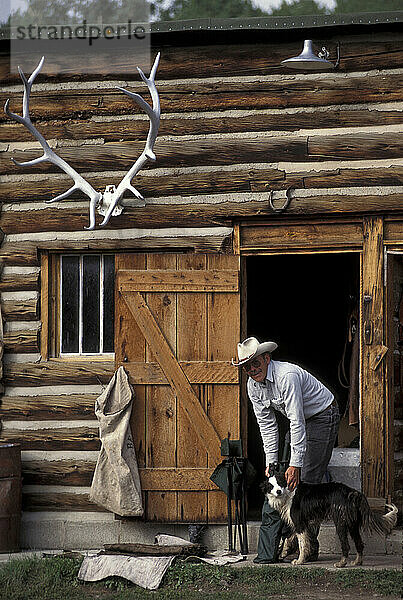 Ein Mann streichelt seinen Hund auf der Absaroka Ranch in Dubois  Wyoming.