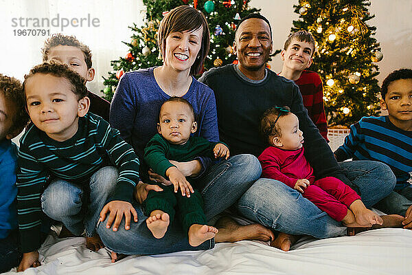 Weiße Mutter und schwarzer Vater zusammen mit Kindern zu Weihnachten