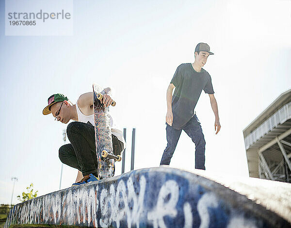 Zwei junge Leute beim Skateboarden in einem Skatepark.