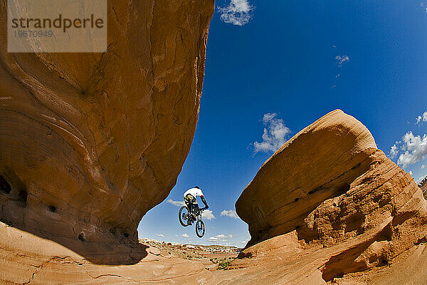 Mountainbiker springt in der Luft von einer Klippe  Moab  Utah.