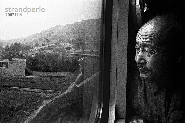 Chinesischer Mann schaut aus dem Fenster eines Zuges (schwarz-weiß)