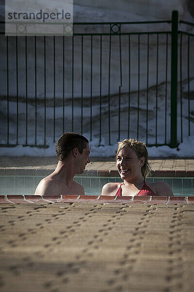 Junges Paar entspannt sich in einem Whirlpool.