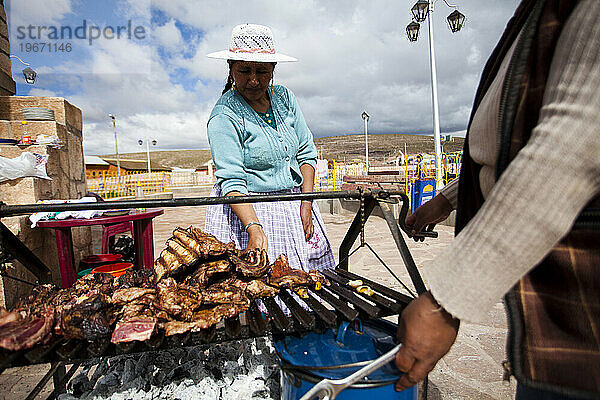 Zwei Frauen grillen Fleisch in einem Gemeinschaftspark in Bolivien.