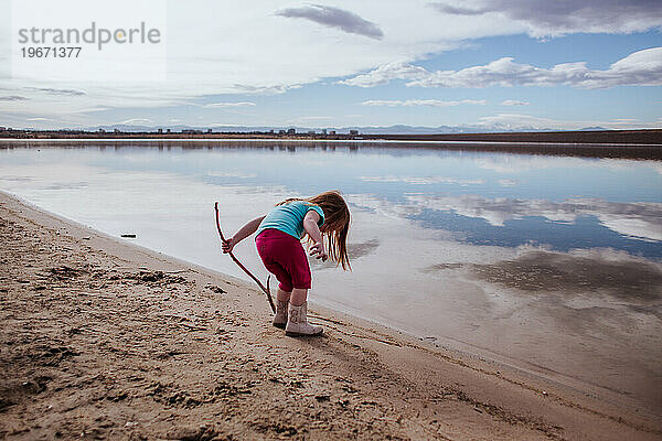 Kleines Kind erkundet die Nähe eines ruhigen Sees