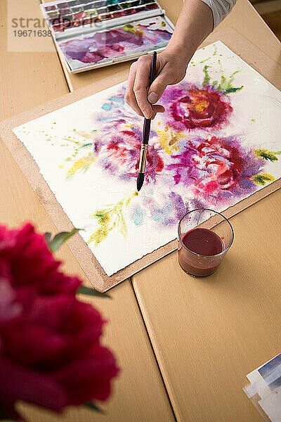 Der Künstler malt Blumen mit Wasserfarben  Nahaufnahme