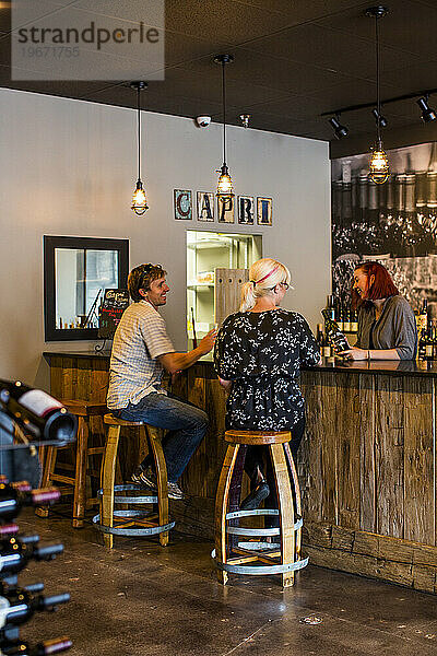 Ein Paar sitzt an der Bar eines Weinverkostungsraums und genießt einzigartige Weine aus dem gesamten Nordwesten.