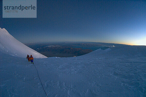 Zwei Bergsteiger bei Sonnenaufgang auf Gurla Mandhata  Tibet.