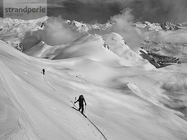 Zwei Personen gehen auf Skitour in den französischen Alpen.