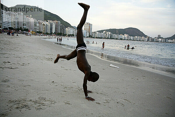 Kind macht Akrobatik am Strand der Copacabana  Rio de Janeiro  Brasilien.
