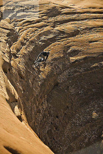 Mann fährt mit dem Mountainbike einen steilen Felsen hinunter in Moab  Utah.