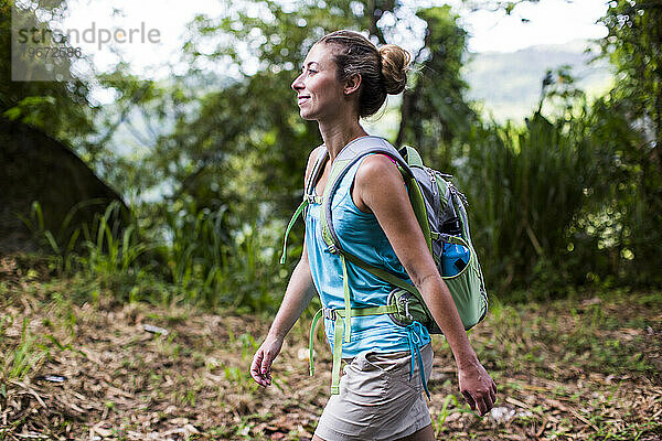 Eine glückliche junge Frau wandert durch den Wald von Puerto Rico
