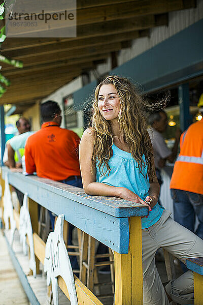 Eine schöne Frau sitzt an einer Bar im Freien in einer kleinen Stadt in Puerto Rico.