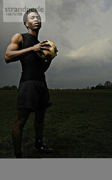 Young adult with soccer ball.