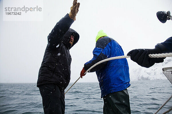 Eine Gruppe Männer organisiert den Transport eines riesigen Eisbergs vor der Küste von Whittier  Alaska.