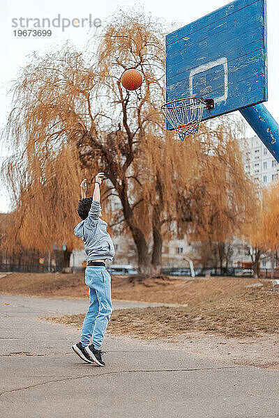 Ein junger Mensch spielt Basketball.
