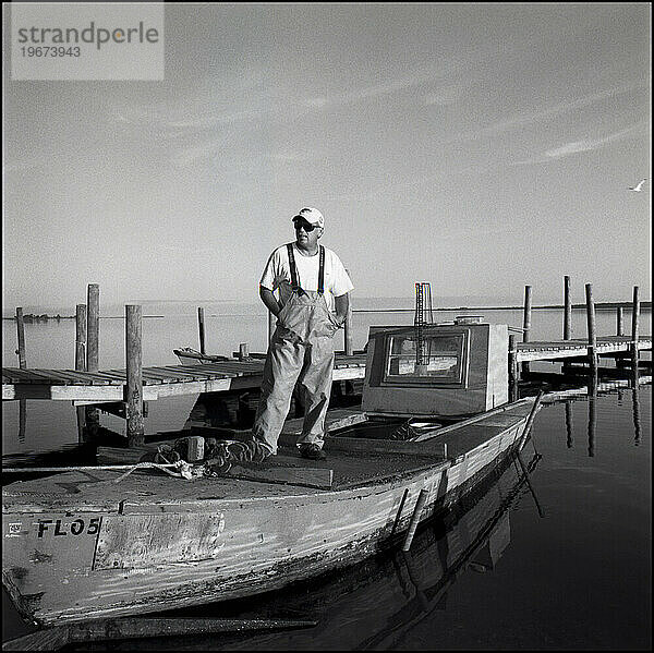 Ein Mann steht auf seinem Austernboot  nachdem er einen Tag lang Austern geharkt hat  Apalachicola  Florida.