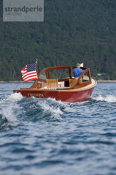 Älterer Mann fährt eine Motoryacht in Somes Sound  Maine.