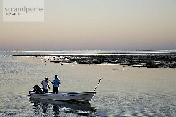 Bei Sonnenaufgang treibt ein Boot in den ruhigen Gewässern in der Nähe von Tobou  Fidschi.