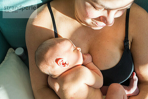 Draufsicht auf eine Mutter  die ihr Neugeborenes hält  Haut an Haut