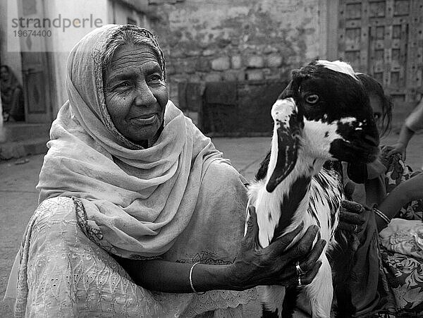 Ältere indische Frau und Ziege (schwarz und weiß)