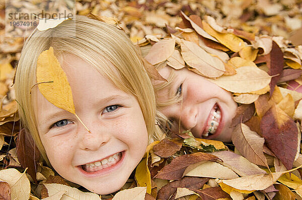 Zwei Mädchen spielen im Herbstlaub in Fort Collins  Colorado.