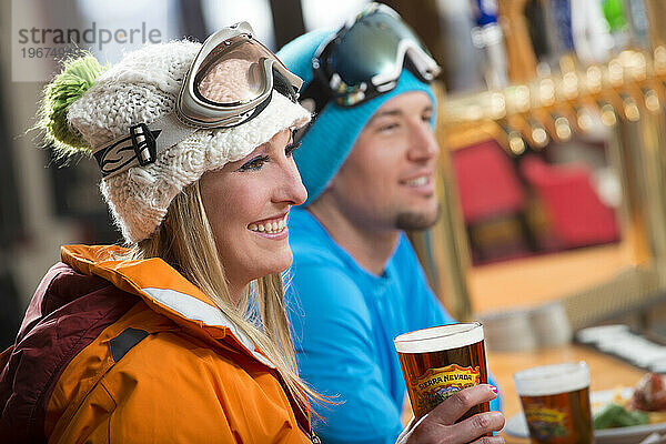 Ein Paar genießt beim Après-Ski im Winter in Kirkwood  Kalifornien  eine Runde Bier an der Bar des Kirkwood Mountain Resort.