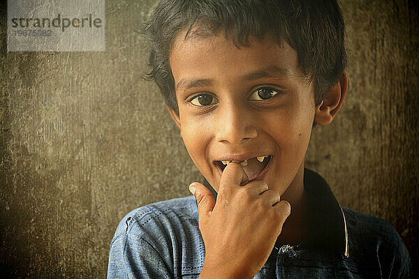 Ein kleiner Junge aus Sri Lanka mit lächelndem Finger im Mund  Batticoloa  Sri Lanka.