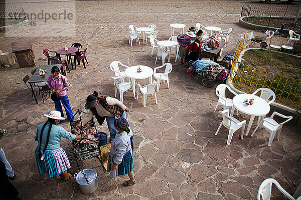 Eine bolivianische Familie macht ein Picknick in einem Gemeinschaftspark im Antiplano von Bolivien.