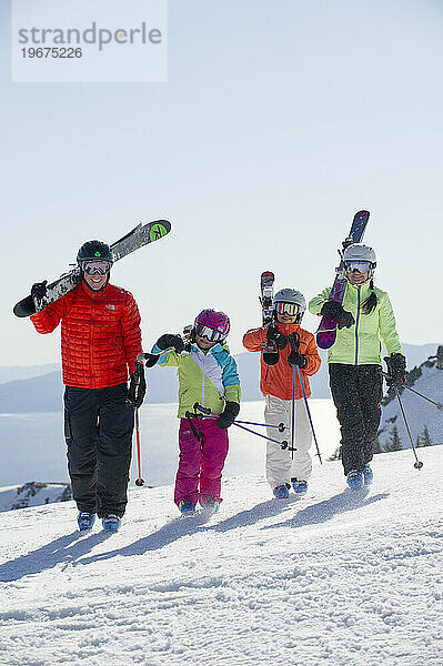 Eine vierköpfige Skifahrerfamilie läuft mit ihren Skiern über der Schulter am Gipfel des Skigebiets Alpine Meadows am Nordufer des Lake Tahoe  Kalifornien.