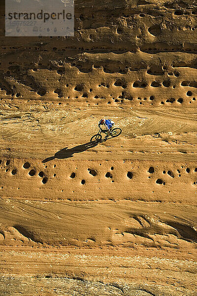 Mann beim Mountainbiken an einer senkrechten Wand in Moab  Utah.