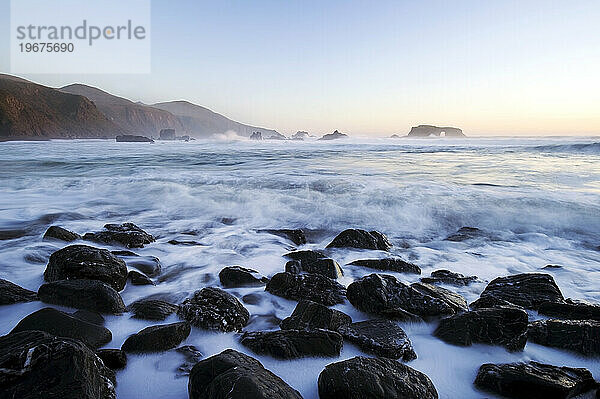 Wellen krachen bei Sonnenuntergang am Blind Beach im Goat Rock State Park an der Küste von Sonoma  Kalifornien.