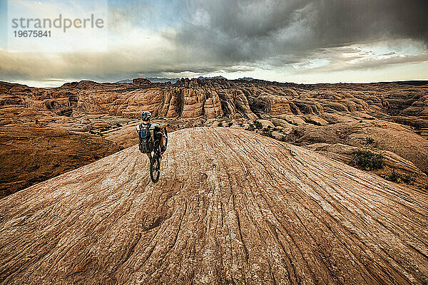 Ein Mann macht einen Wheelie auf einem Mountainbike in der Nähe von Moab  Utah.