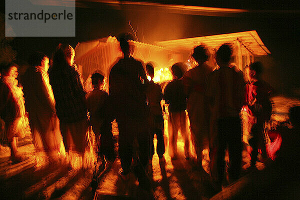 Eine Gruppe der Meca-Dorfbewohner versammelt sich um ihr Abendfeuer. Thailand.