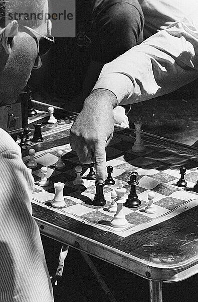 Nahaufnahme von zwei Männern  die draußen in New York City Schach spielen.