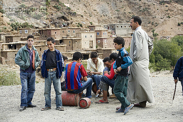 Jugendliche spielen Karten in einem Dorf im Atlasgebirge  Marokko.