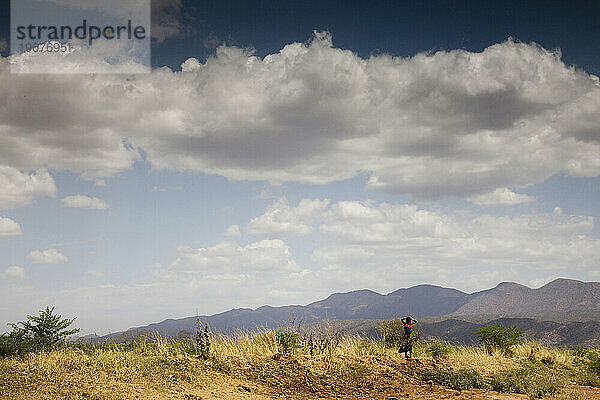 Eine junge Frau steht mit den Händen auf dem Kopf im abgelegenen Omo-Tal.
