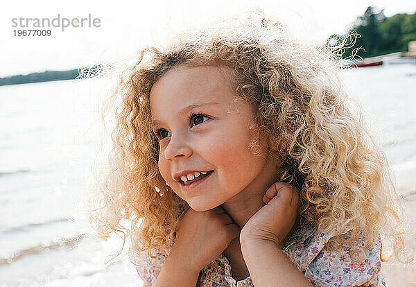 Porträt eines schönen Kindes  das mit blonden Locken lächelt