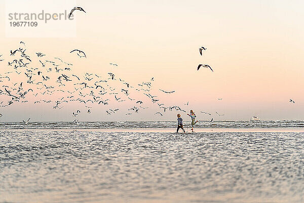 Zwei Kinder am Strand von Texas in der Abenddämmerung