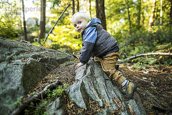 Kleiner Junge klettert auf Felsen in der Natur  abenteuerlustiger Geist