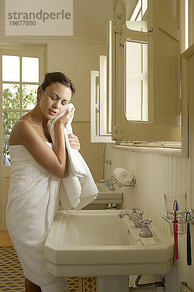 Eine Frau wäscht ihr Gesicht.