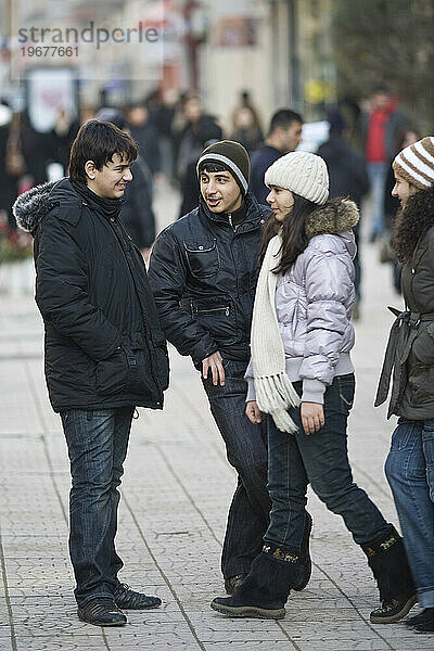 Jungen und Mädchen flirten auf einer belebten Einkaufsstraße in Baku  Aserbaidschan.