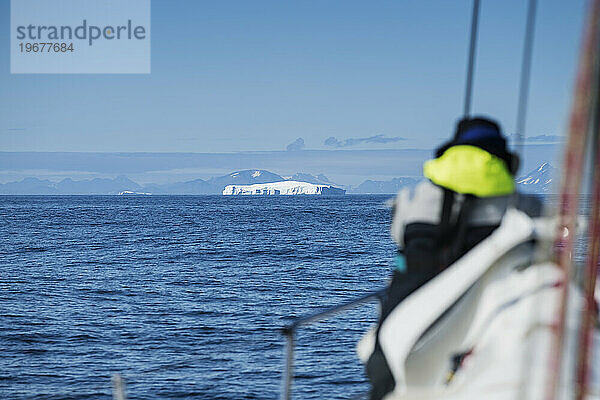 Segeln in Richtung eines großen Eisbergs vor der Ostküste Grönlands
