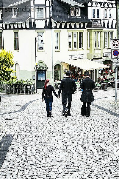 Drei Personen  zwei in Tracht  gehen durch Freudenberg  Deutschland  Europa